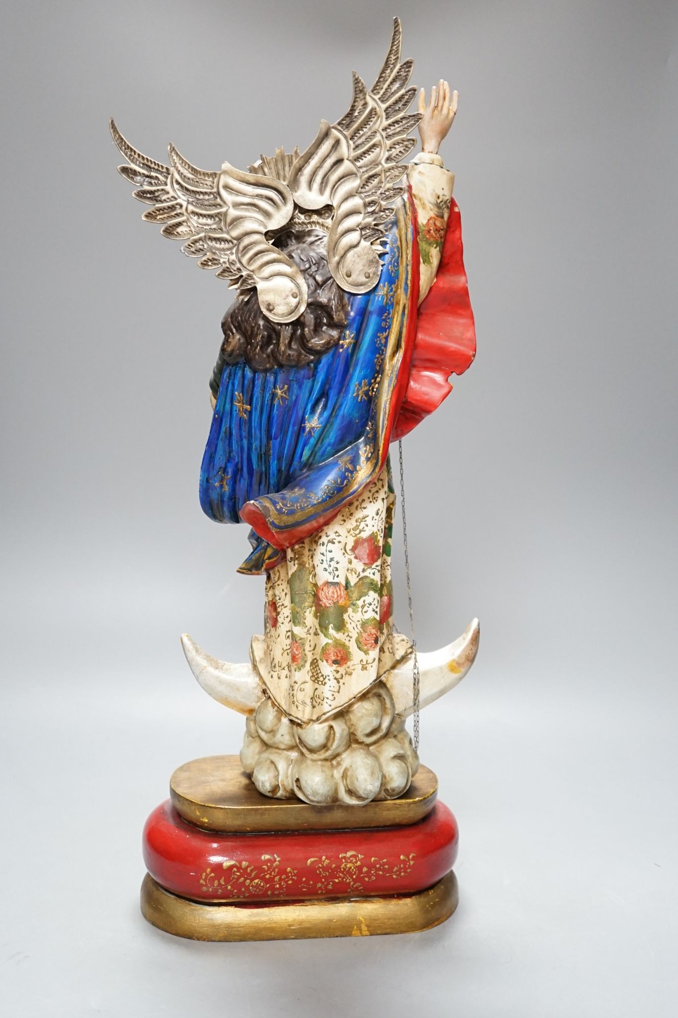 A painted South American angelic figure, standing on a dragon on a crescent moon 49cm